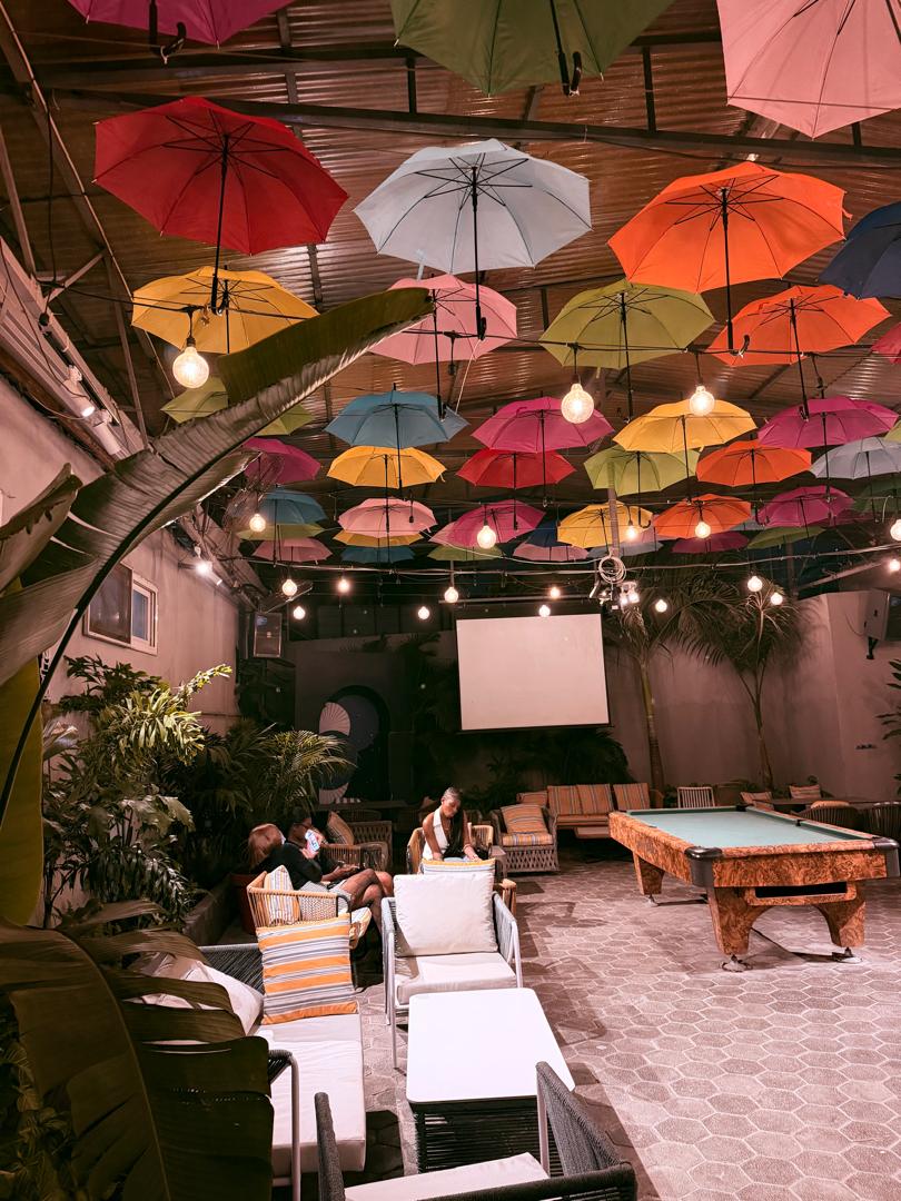 La cour aux parapluies colorés et son billard